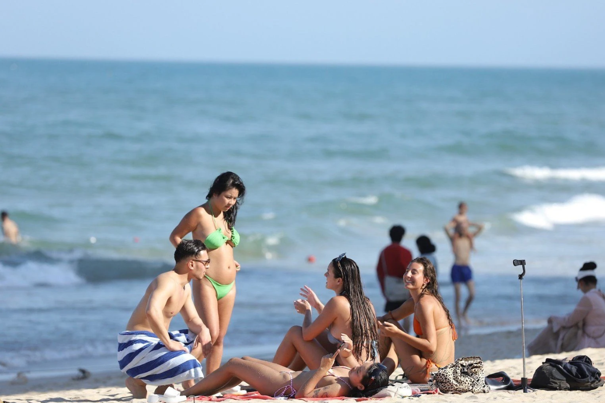 Tourists enjoying surfing and sunbathing at My Khe Beach